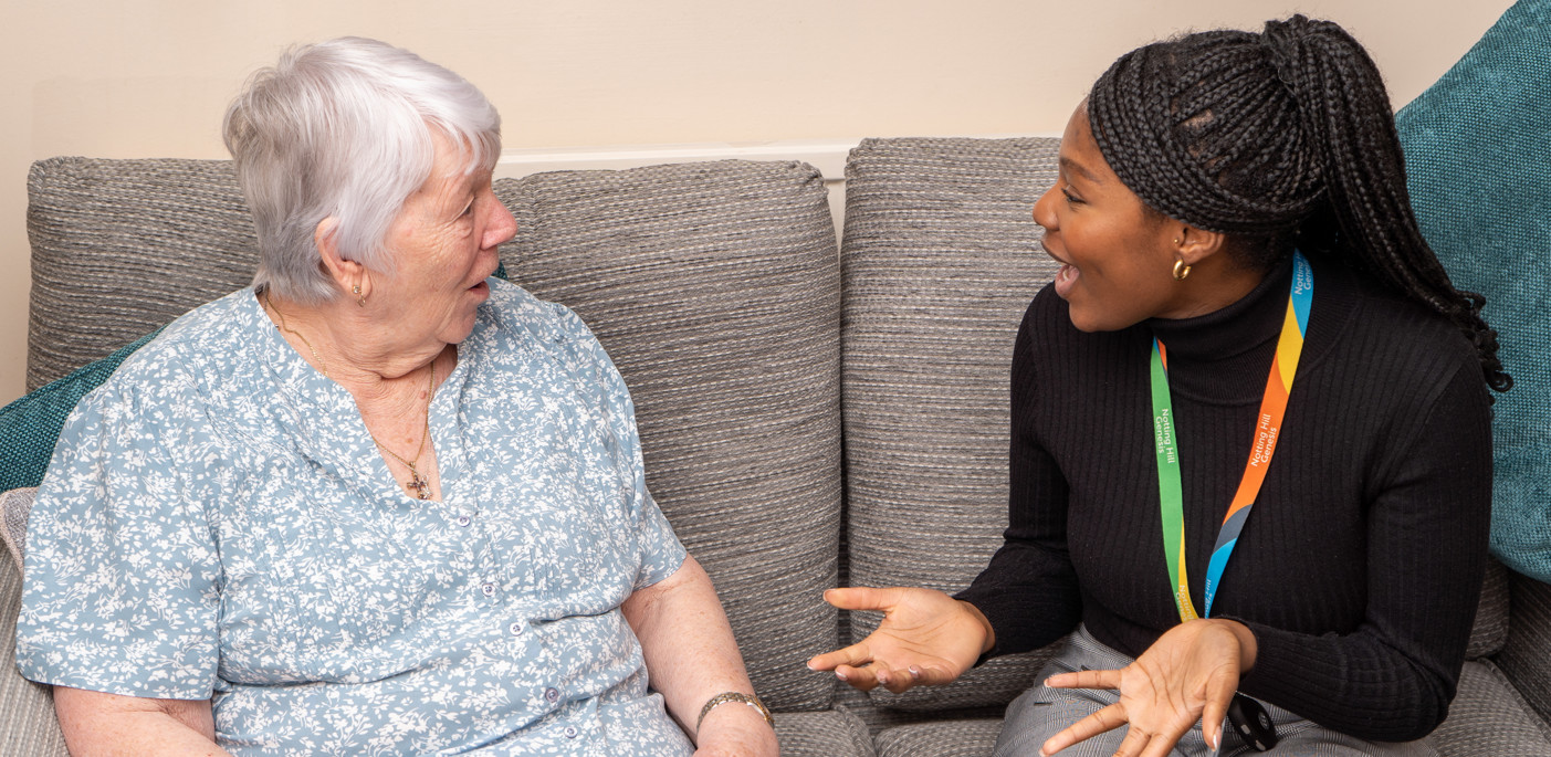 A resident in their home seated with a general needs officer.