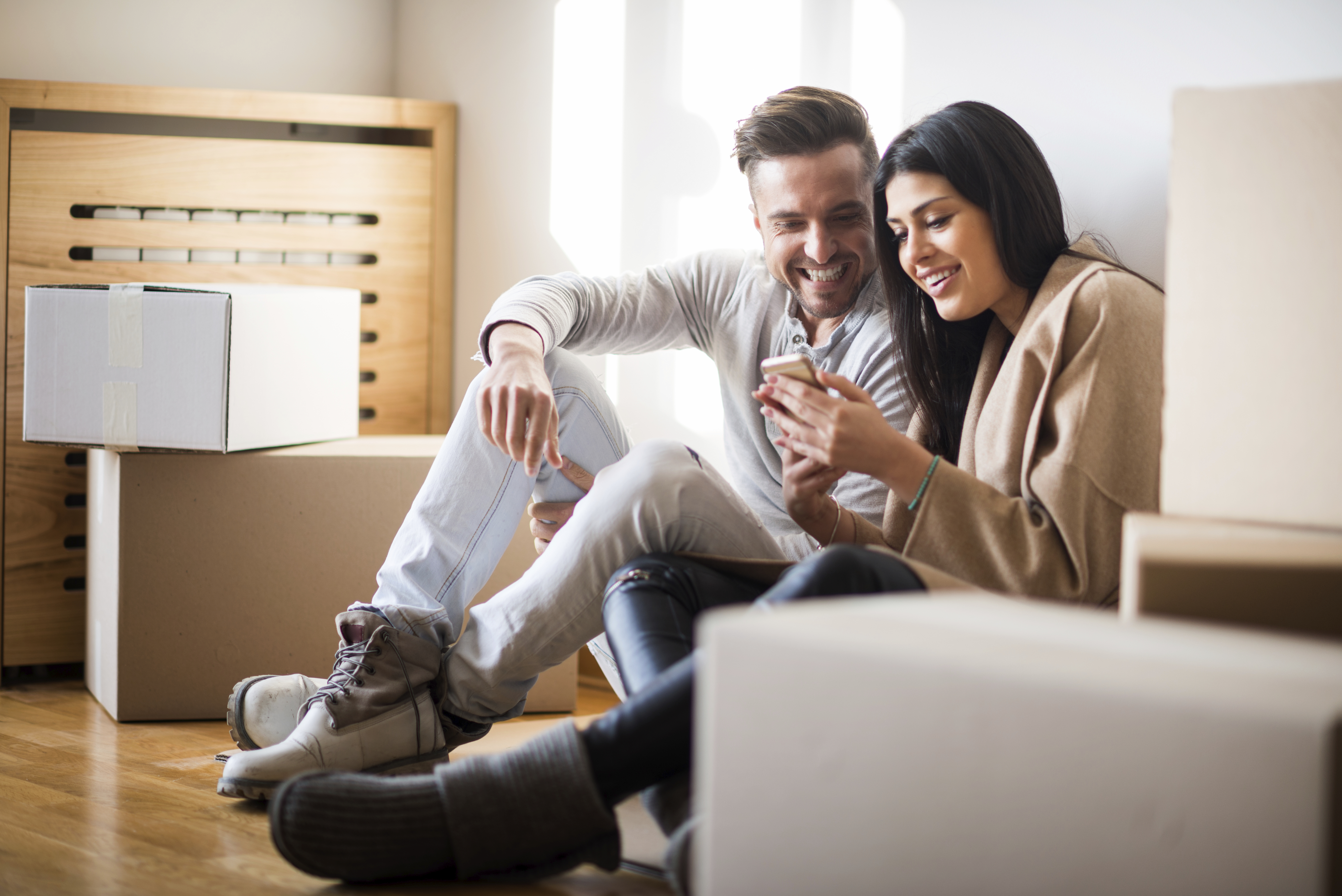 A young couple sitting in their new home. 