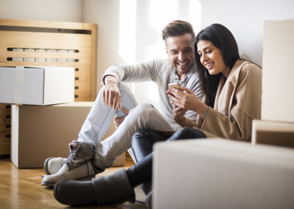 A young couple sitting in their new home. 