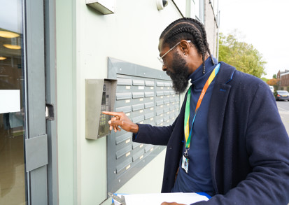 A housing officer arrives at a residential block of flats. 