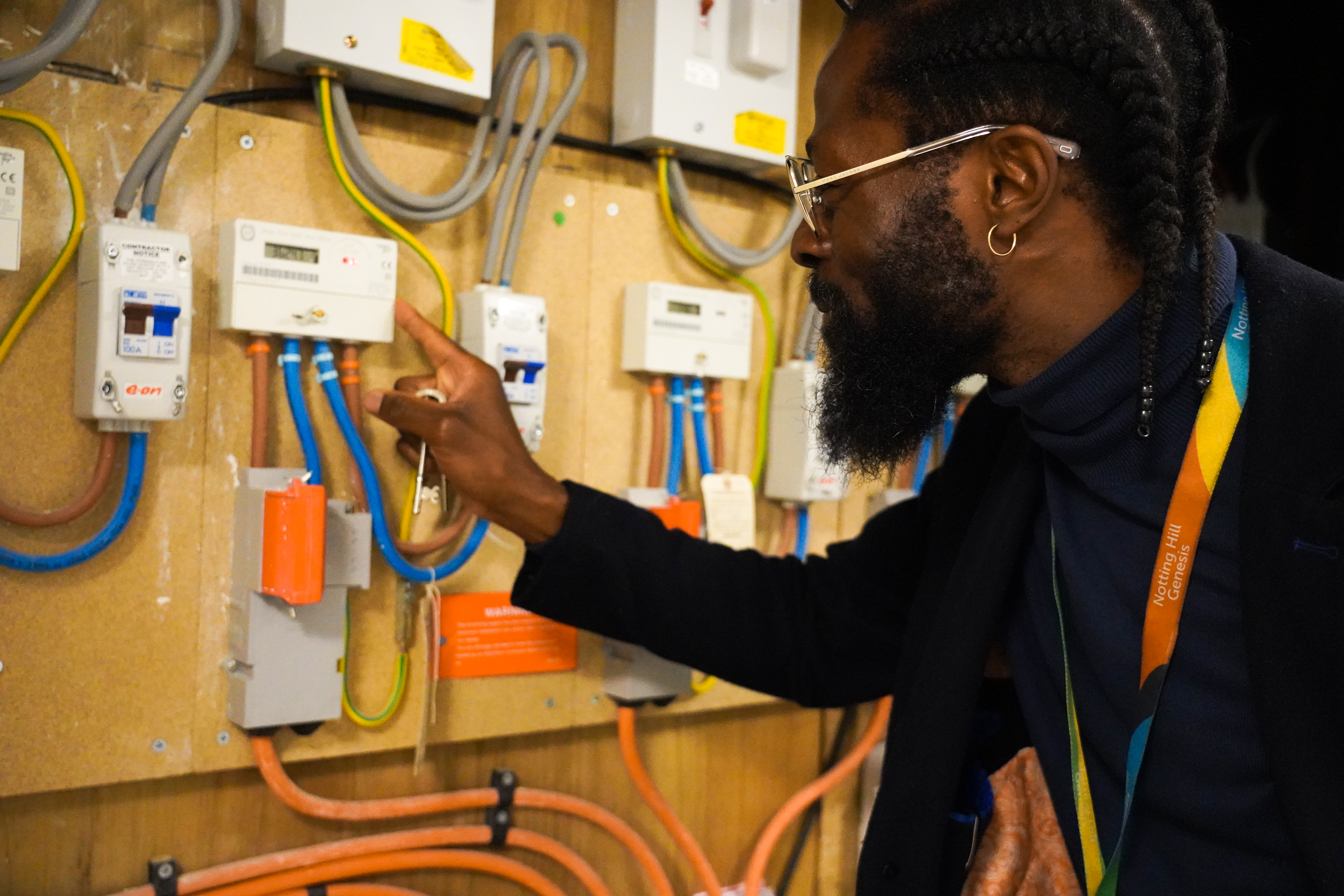 A housing officer looking at an electricity metre.
