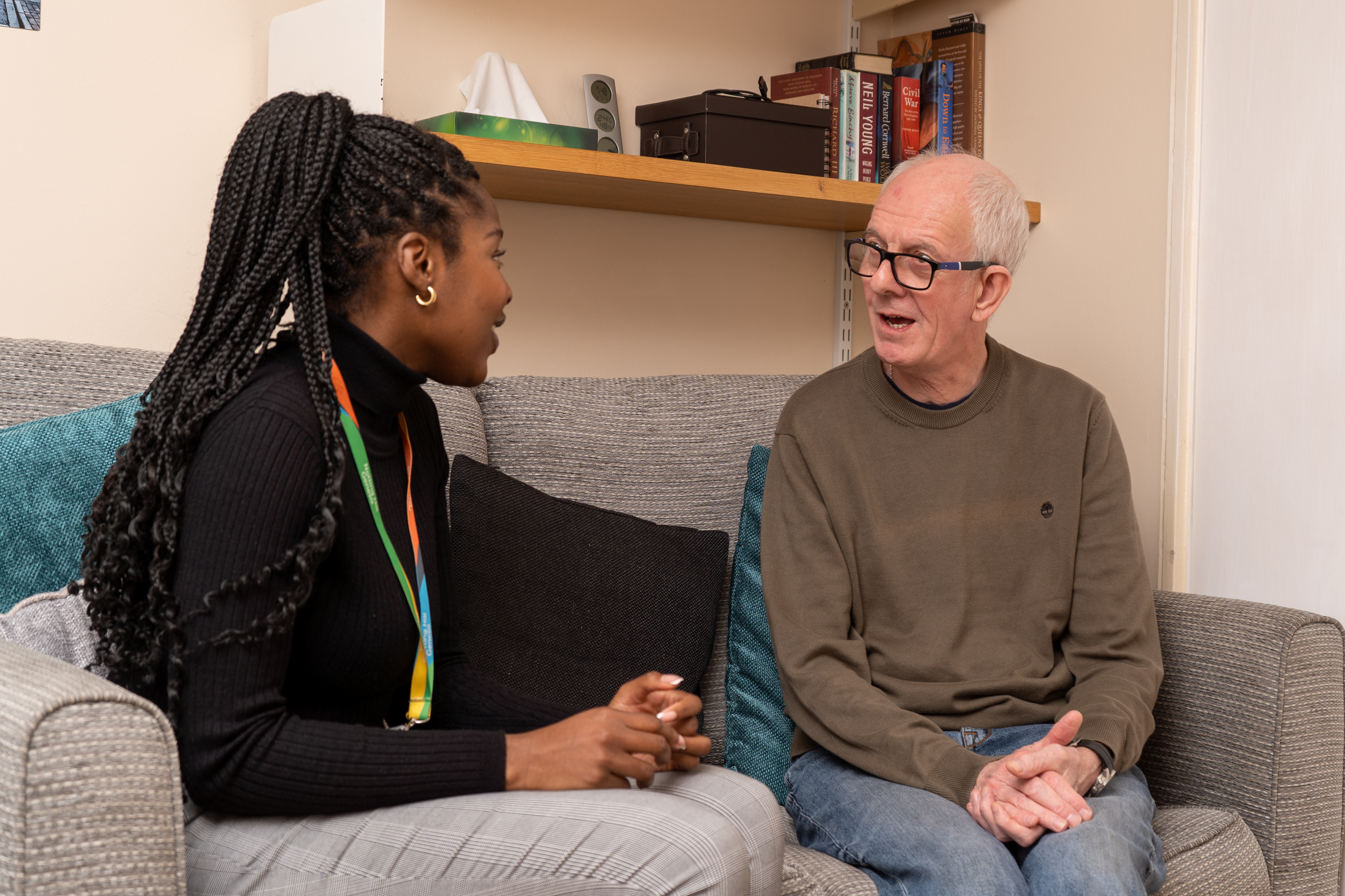 A resident in their home seated with a general needs officer. 