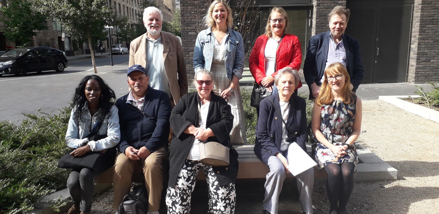 A group of residents sitting on a bench outside offices.