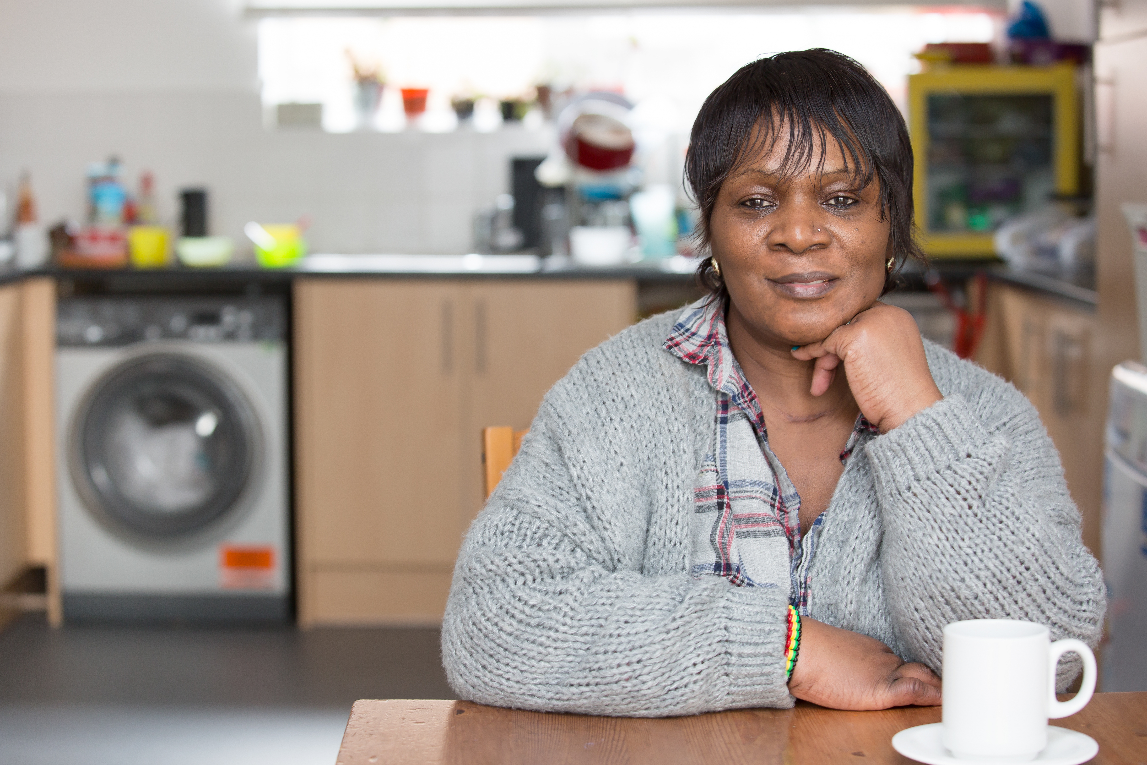 A smiling resident in their home kitchen. 