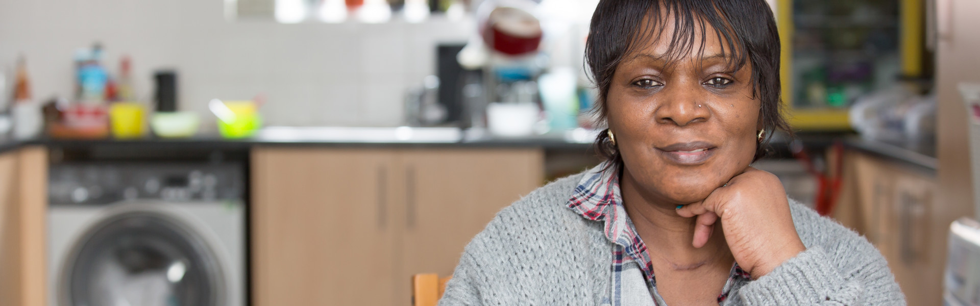 A smiling resident in their home kitchen.