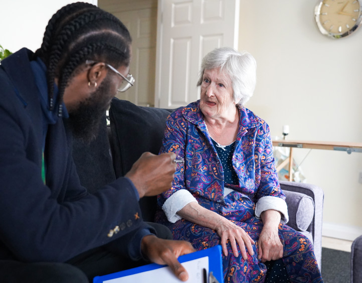A resident in their home joined by a housing officer.