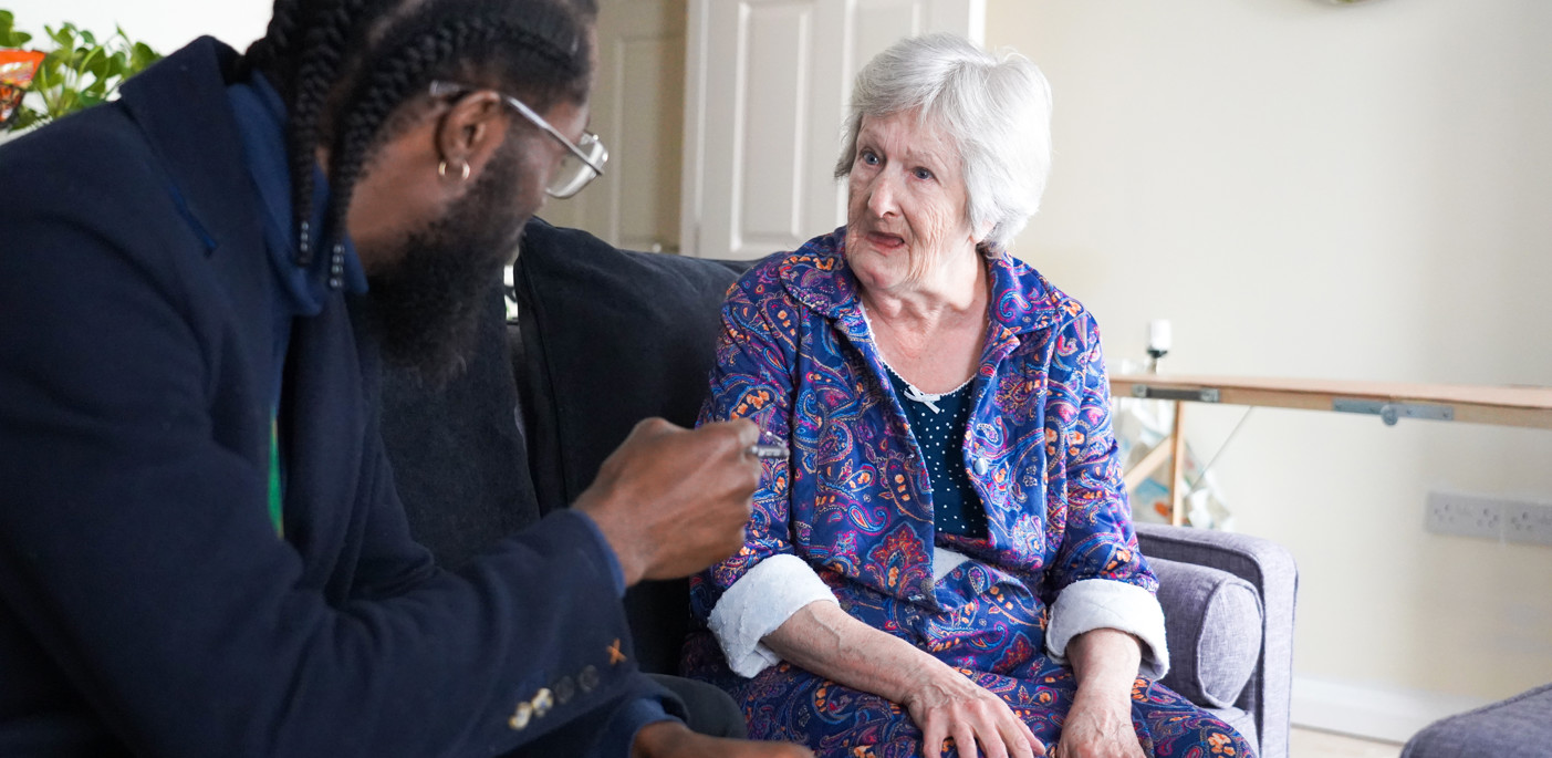 A resident in their home joined by a housing officer.